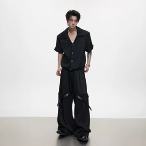 Detail of high-end trousers featuring industrial belt and metal buttons