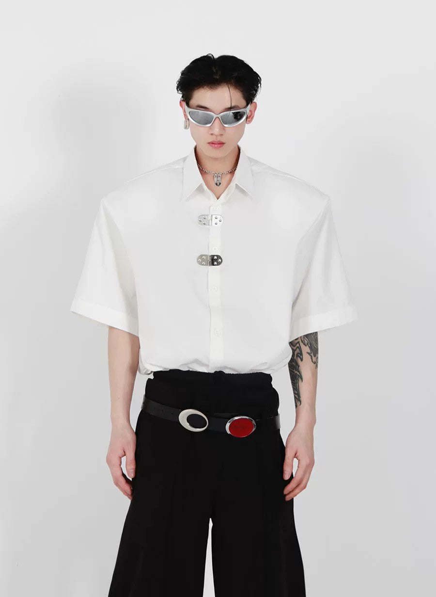 Front view of white avant-garde shirt with shoulder pads and metal buckles