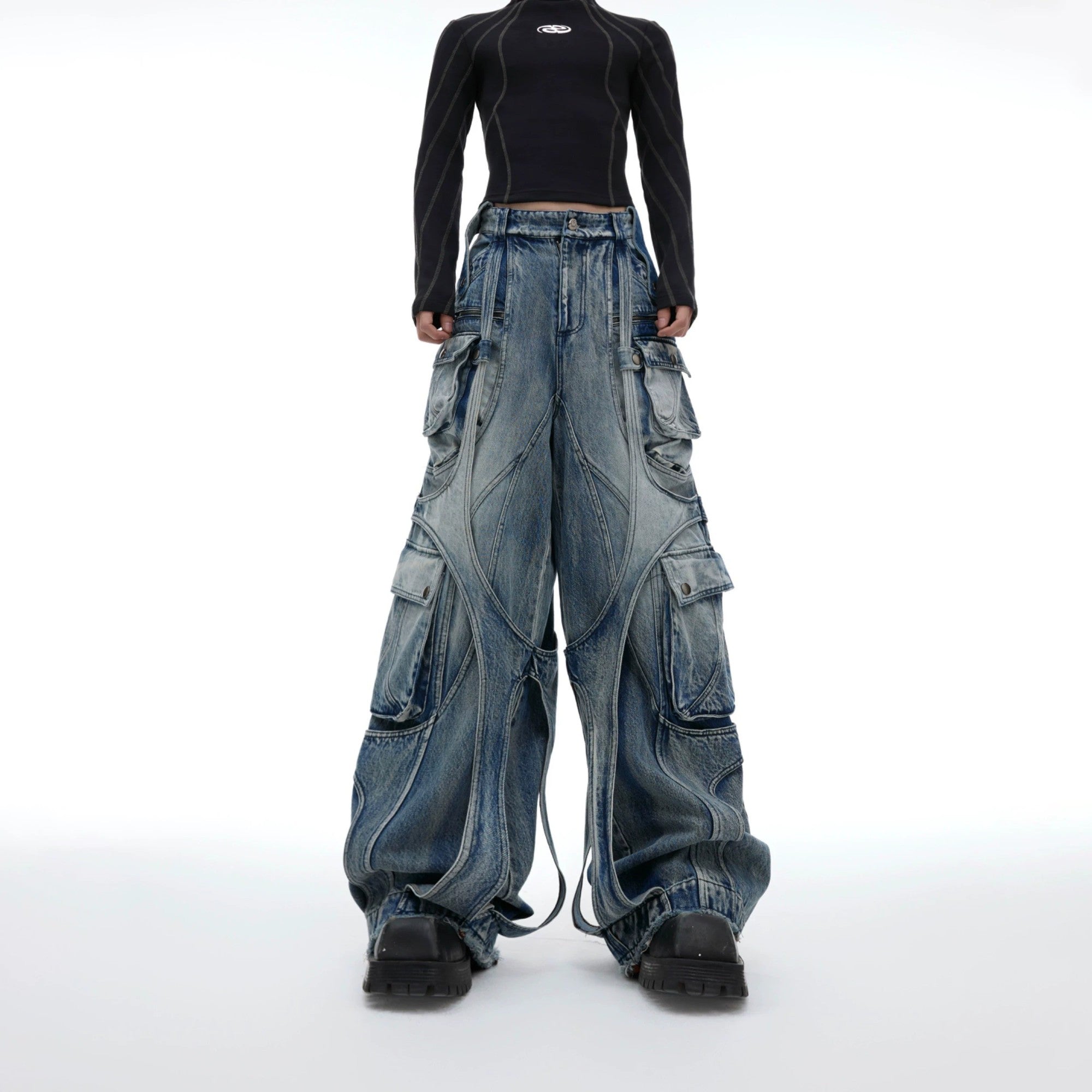 Front view of baggy blue distressed cargo jeans with raw edge straps