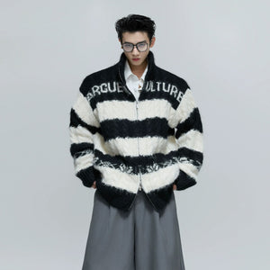 Model wearing a loose fit knitted sweater in a street setting.