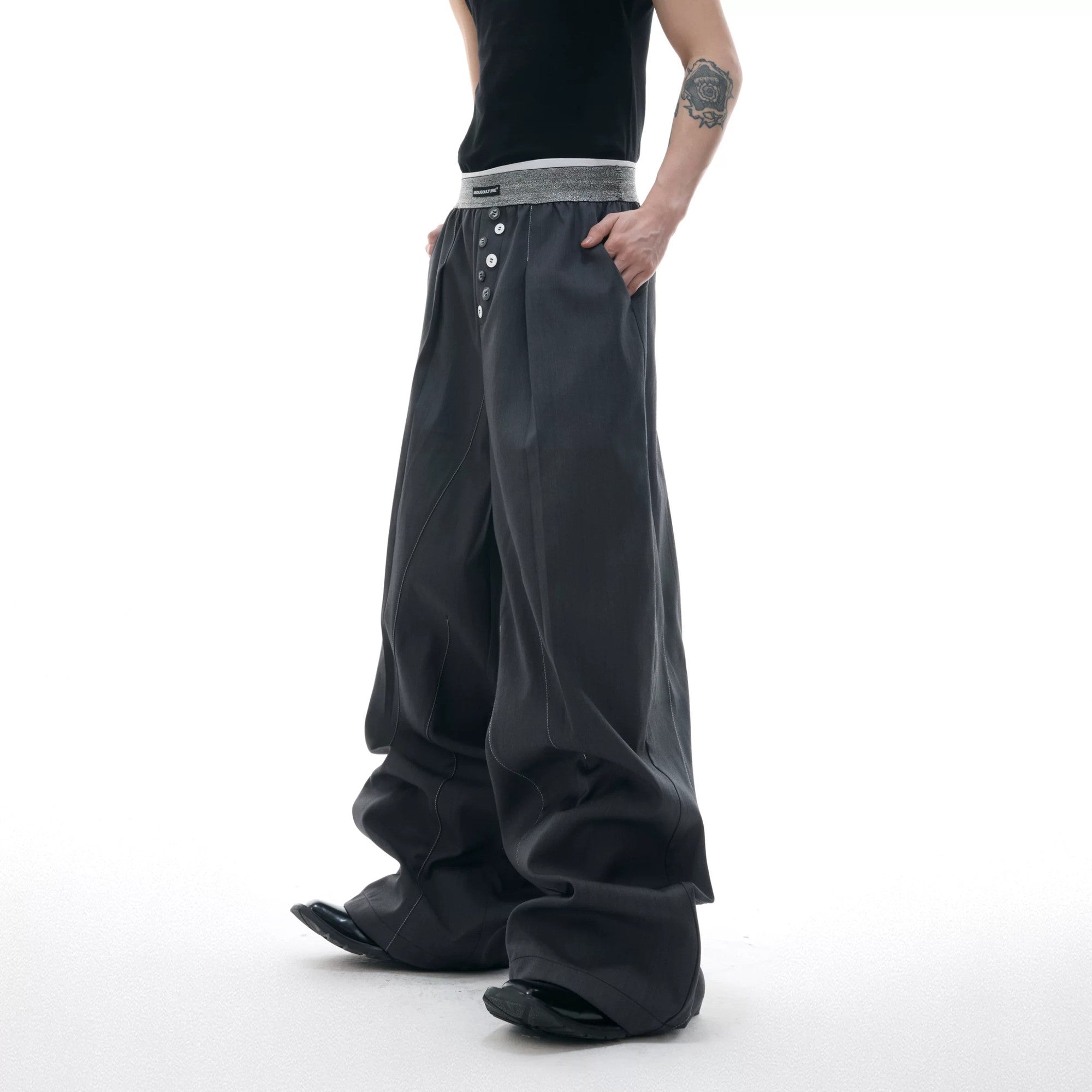 Side view of gray wide leg streetwear pants showing the 3D tailoring
