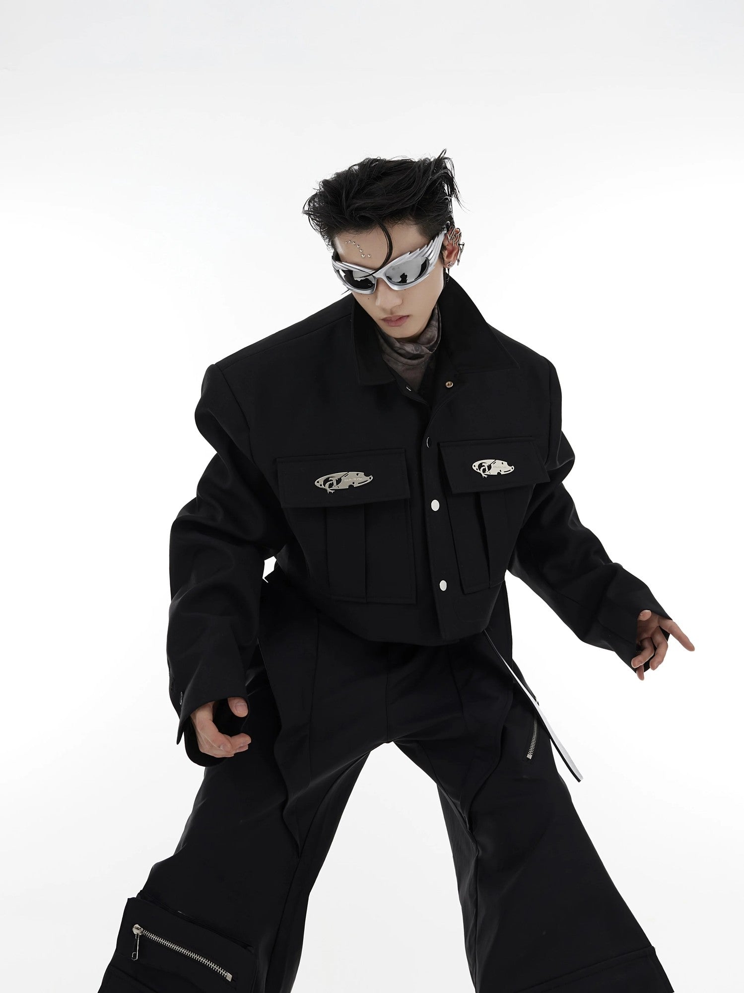 Front view of black cropped utility jacket with 3D pockets and metal details