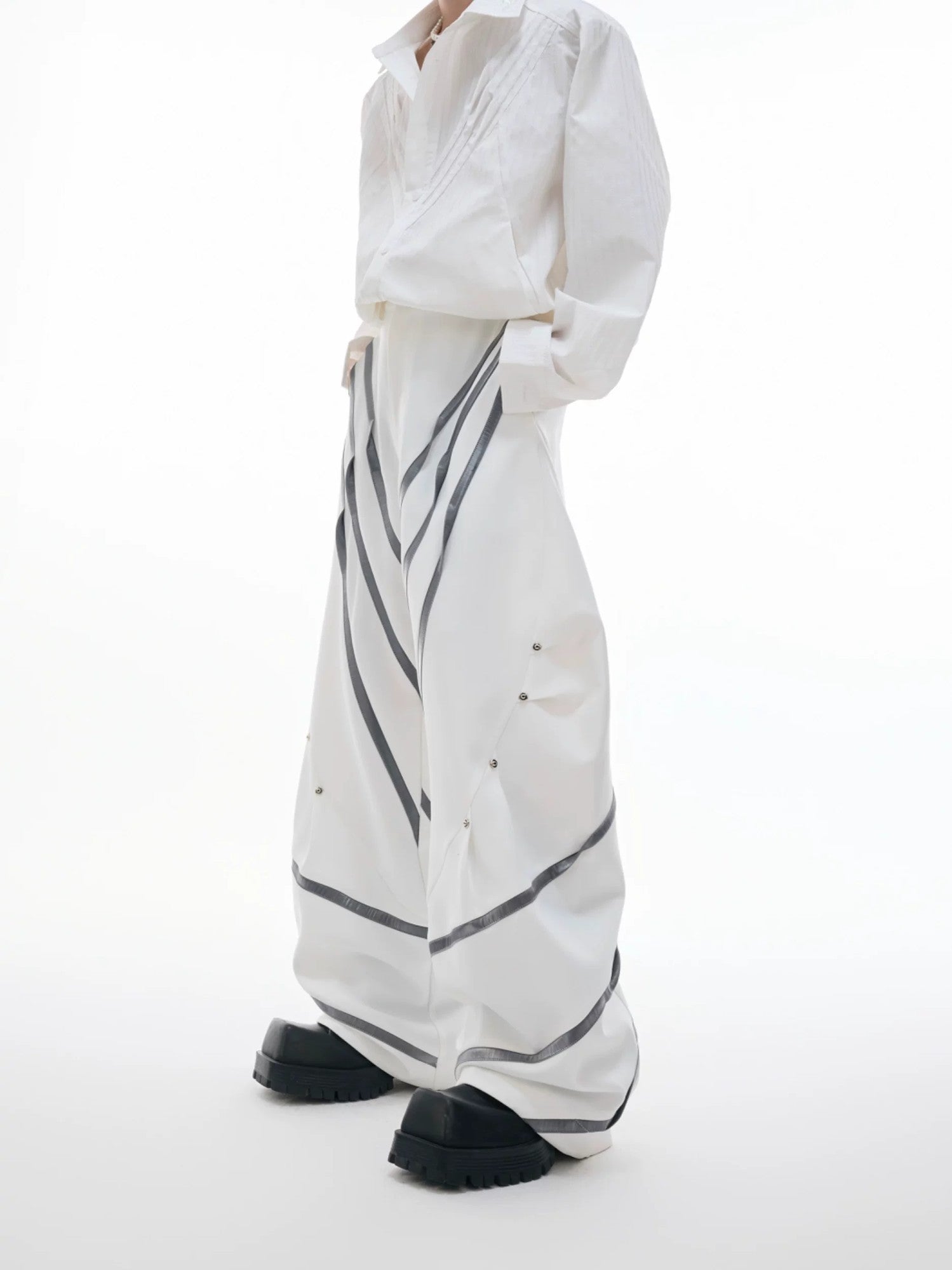 Black deconstructed trousers with 3D cut and metal rivet details front view