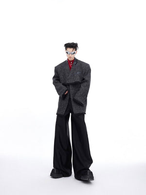 Male model wearing a loose fit deconstructed blazer in an urban setting.