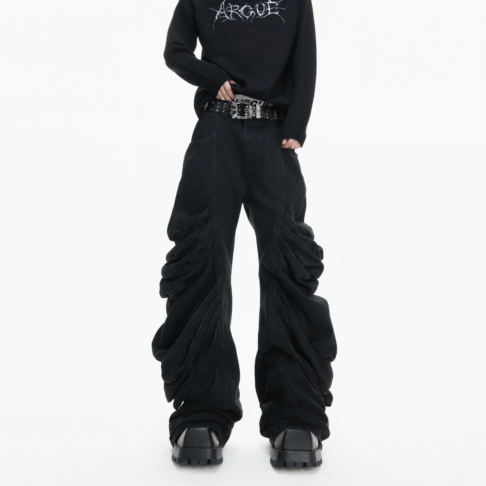 Front view of black deconstructed stacked denim jeans with pleated details