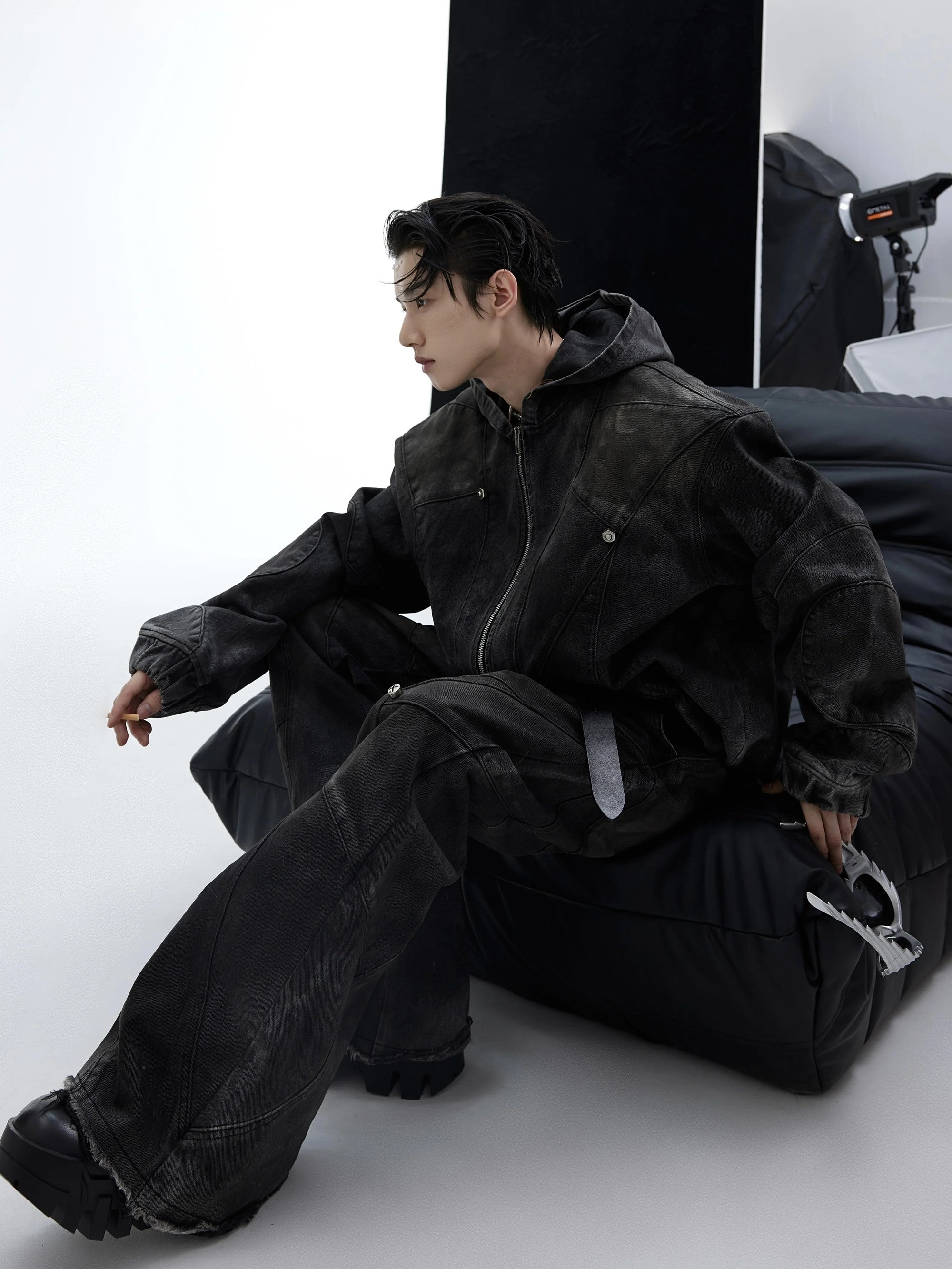 Side view of matching distressed denim pants with metal accents