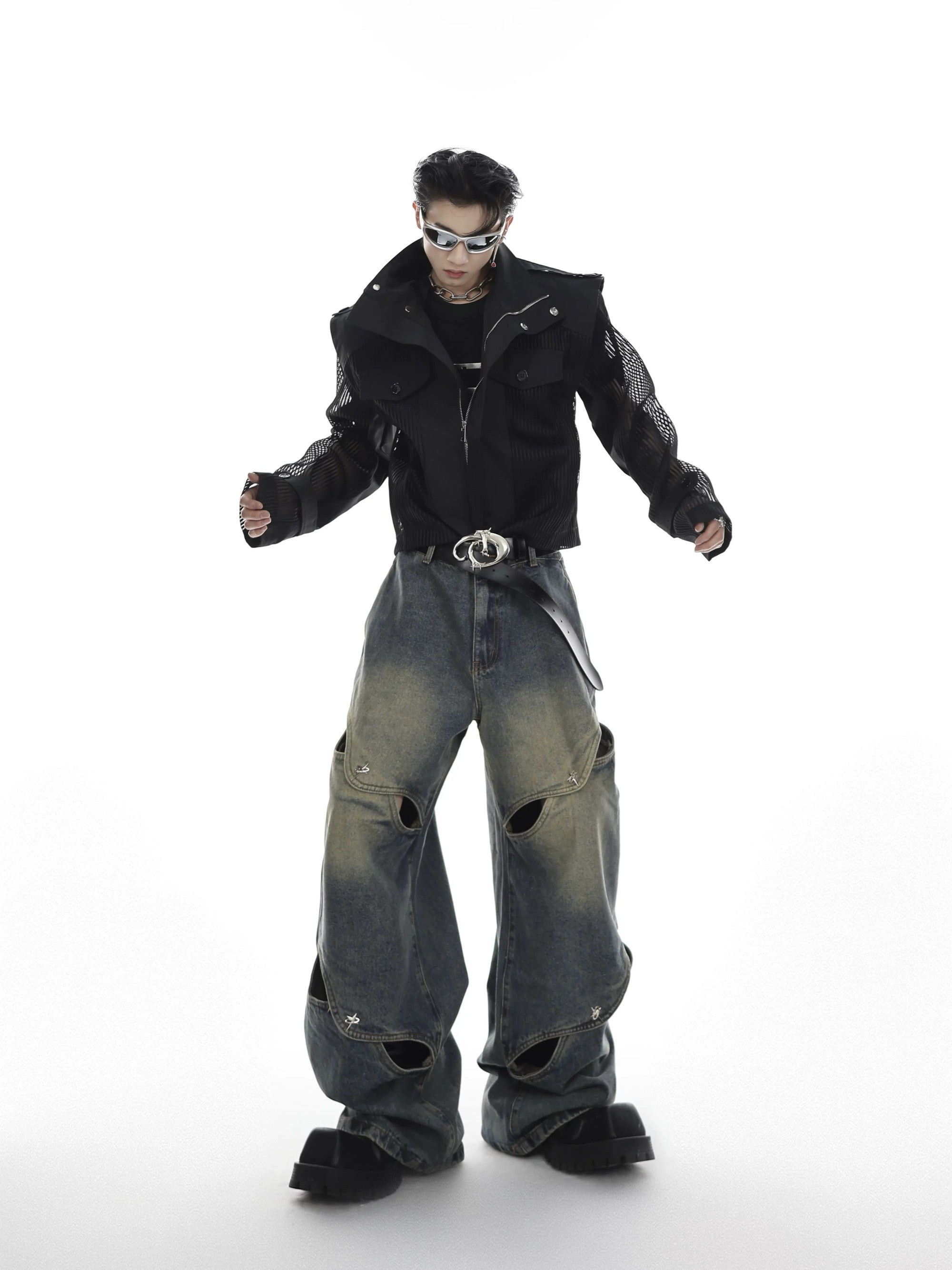 Close-up of the metal button and hollow-out design details on punk jeans