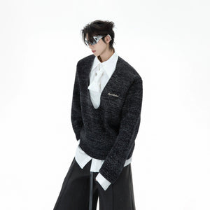 Front view of a grey oversized sweater with a built-in tie and shirt collar.