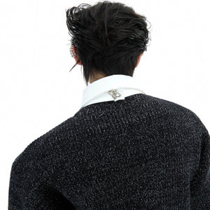 Close-up of the built-in tie and hardware detailing on the knit sweater.