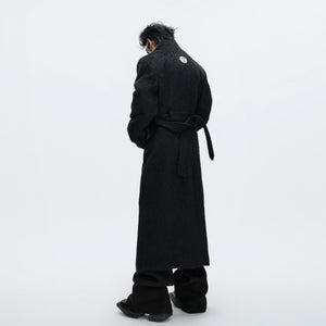 Model wearing a long white wool trench coat in an urban setting