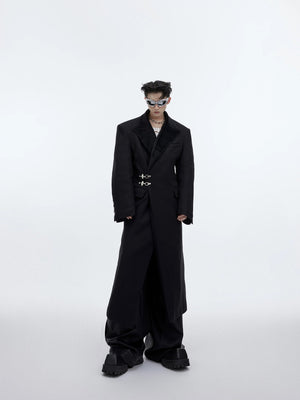 Front view of an oversized deconstructed long wool coat with metal buckles.