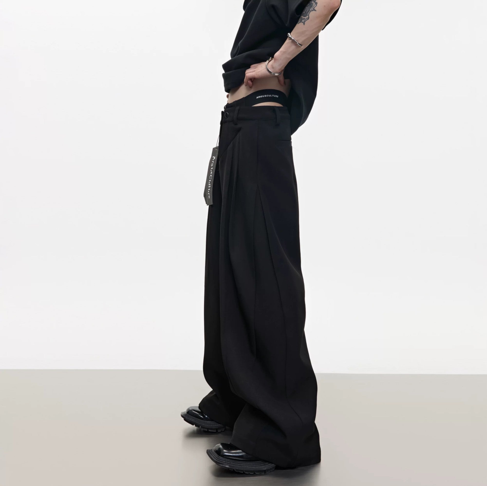 Front view of deconstructed wide-leg pants with metal zipper detail