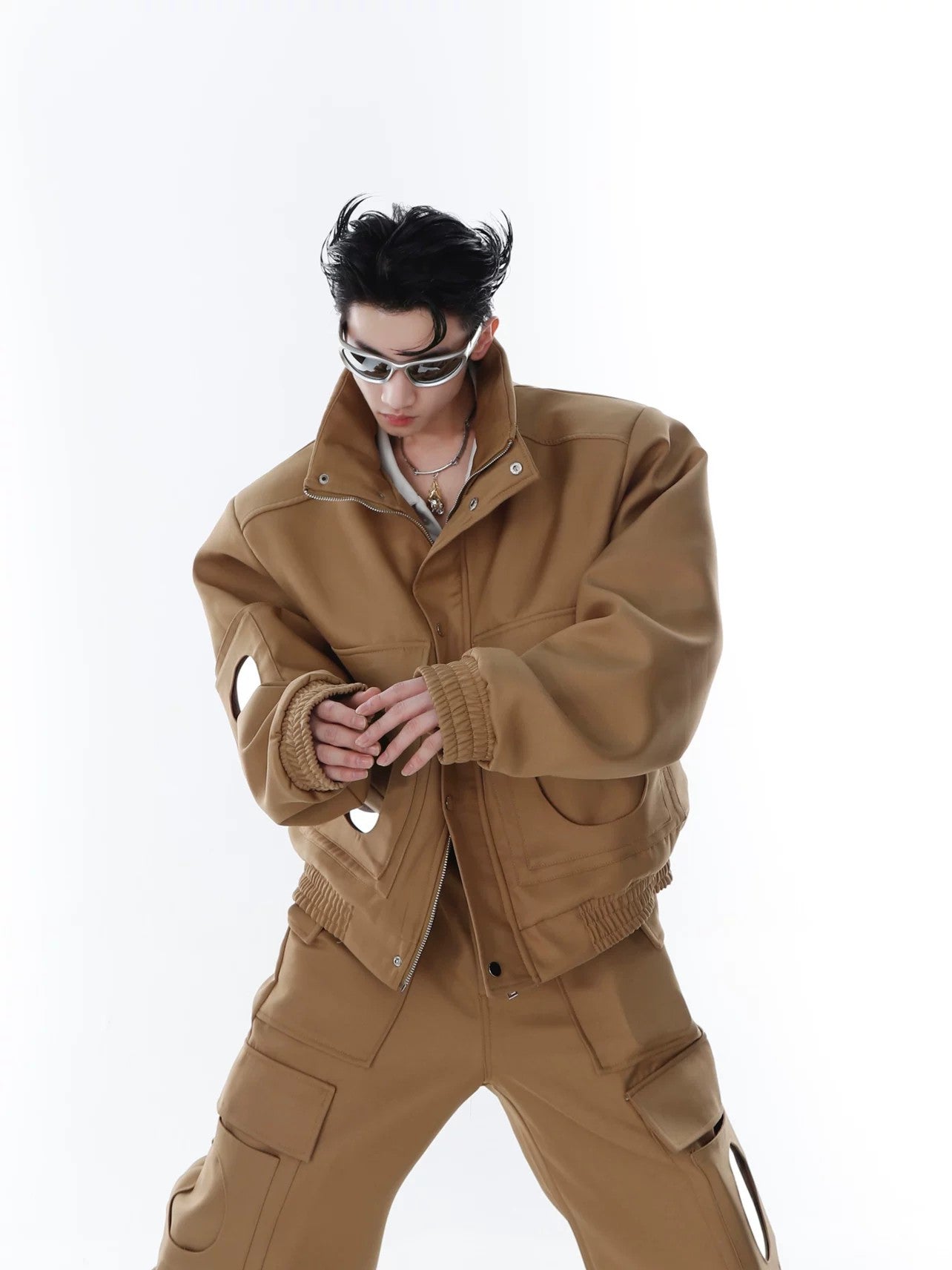 Front view of a khaki deconstructed jacket with mirror patchwork and padded shoulders.