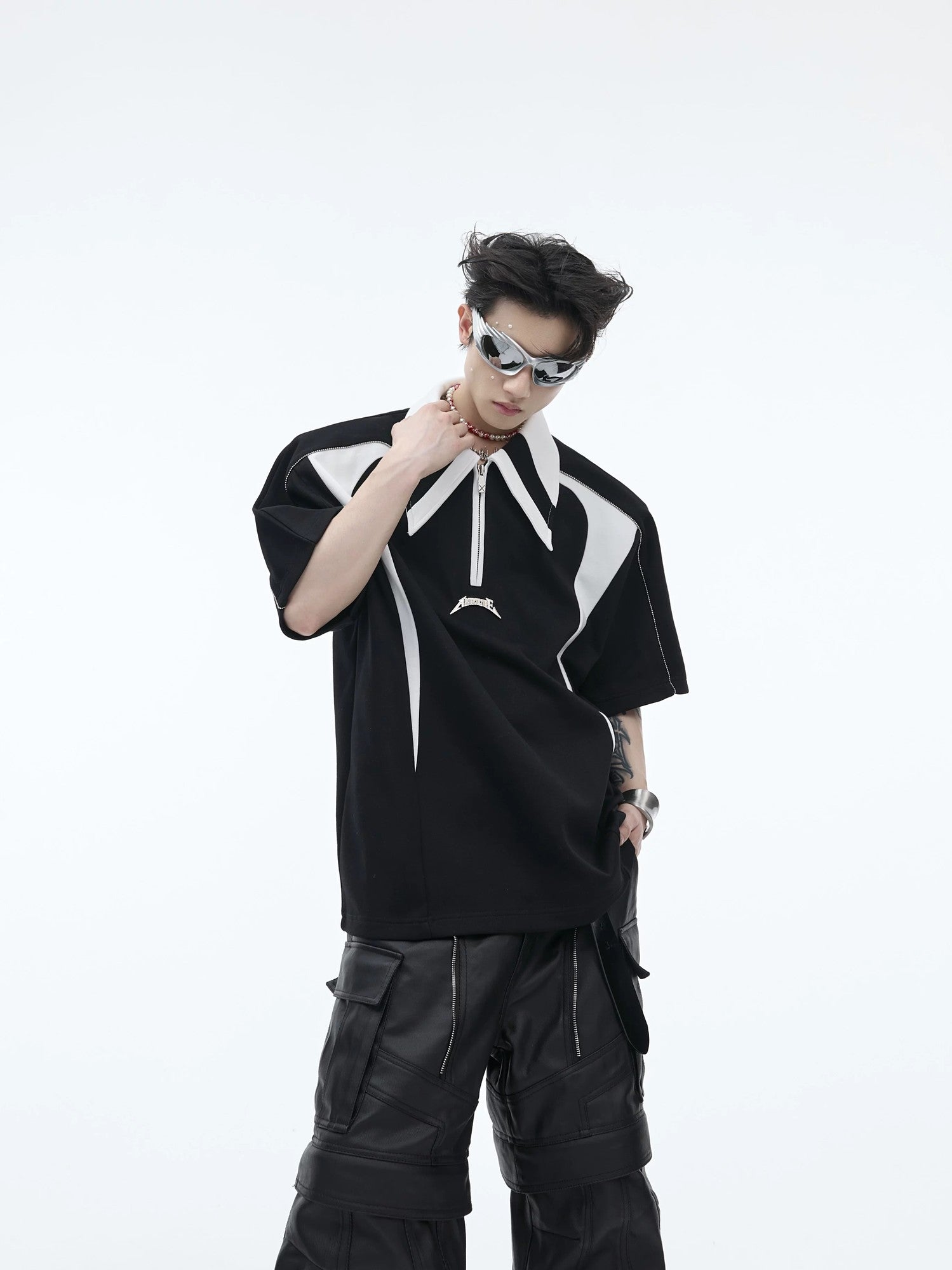 Front view of a white deconstructed polo shirt with shoulder pads and metal details.