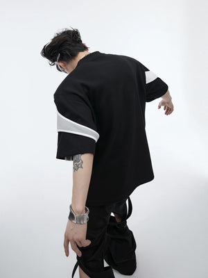 Male model wearing a red boxy deconstructed tee in an urban setting