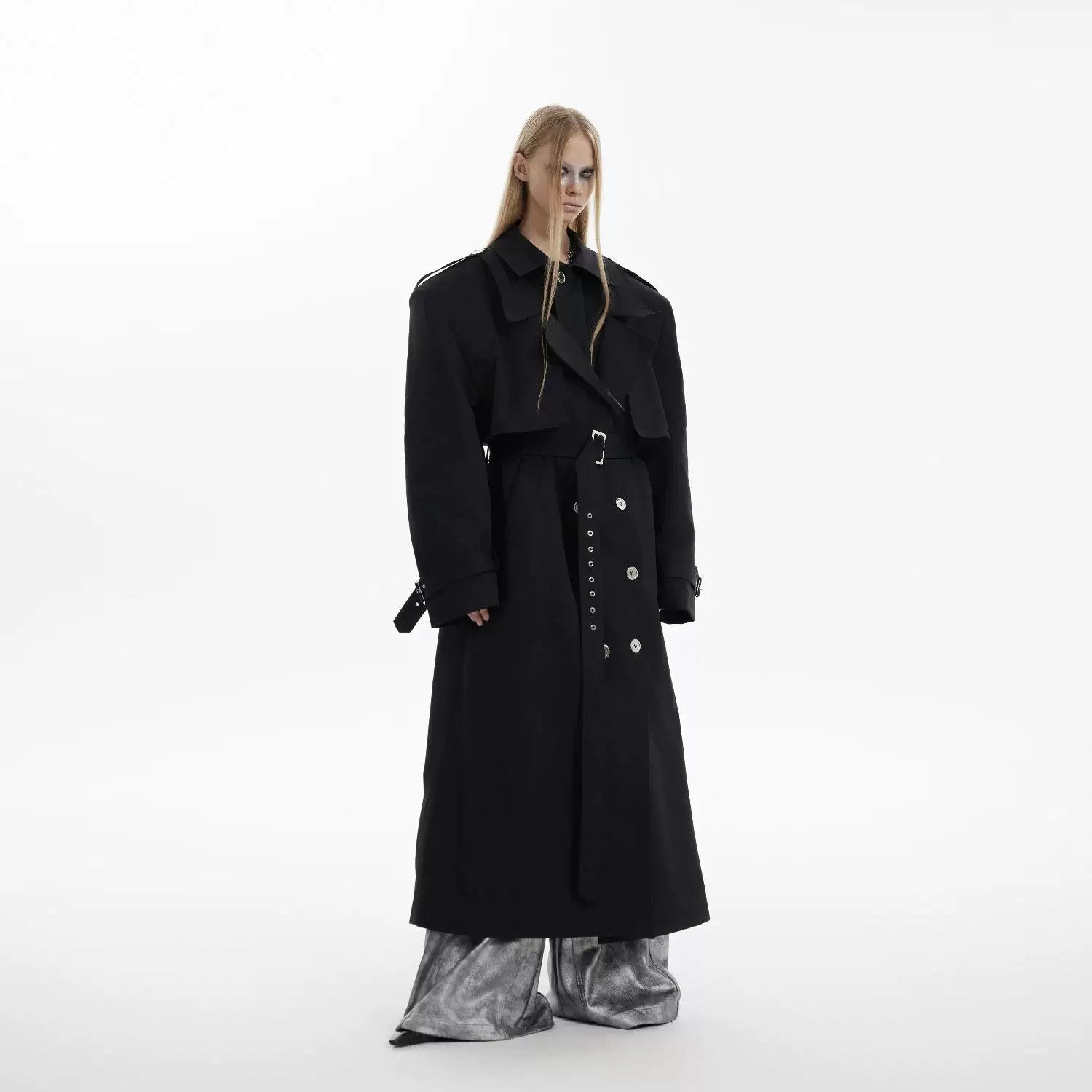 Close-up of the padded shoulders and double-breasted design on a long trench coat.