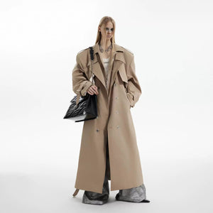 Back view showing the longline silhouette and deconstructed hem of the coat.