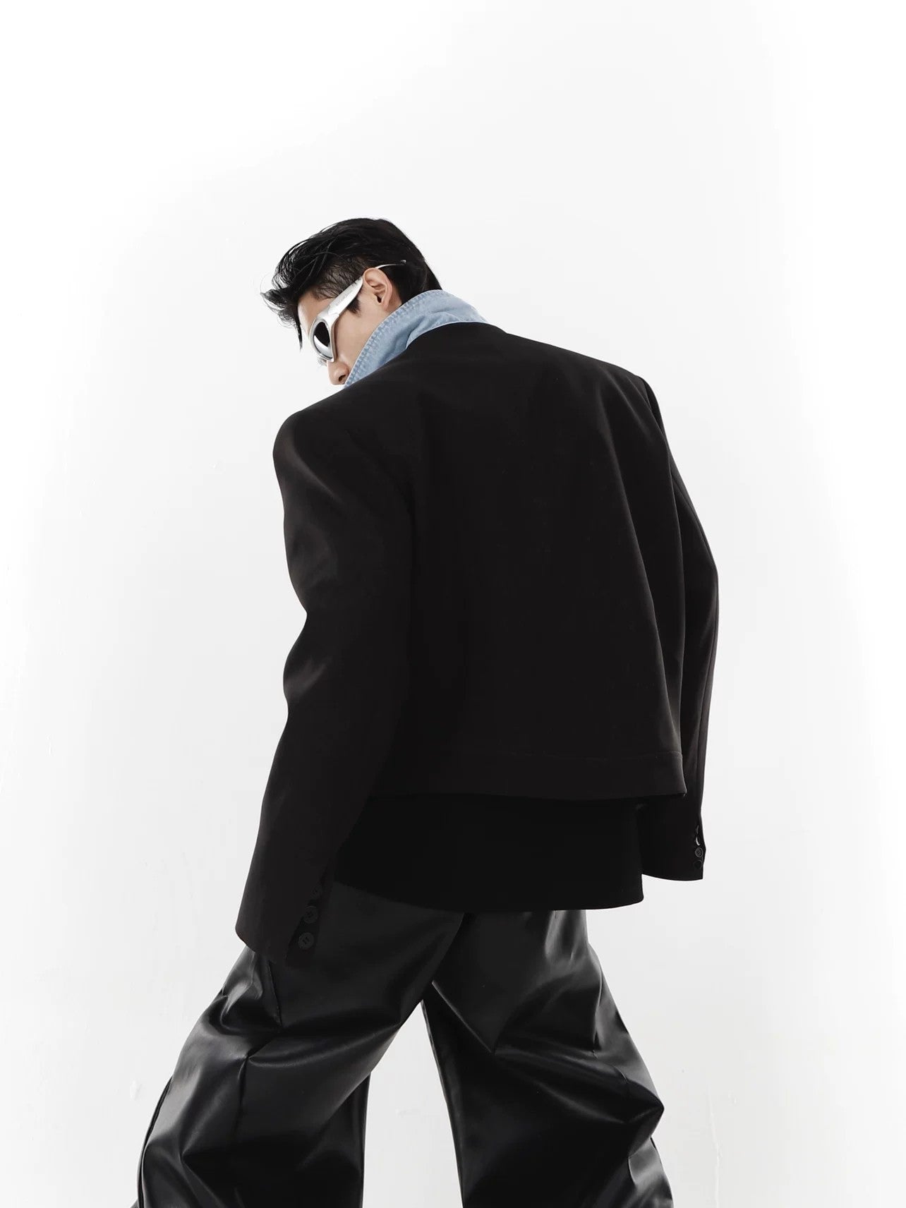 Close up of padded shoulders and patchwork fabric on a streetwear jacket.