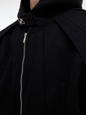 Model wearing gray deconstructed hoodie and pants set in urban setting