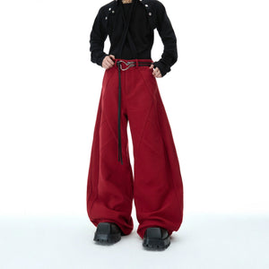 Side profile of black deconstructed streetwear pants showing split lines