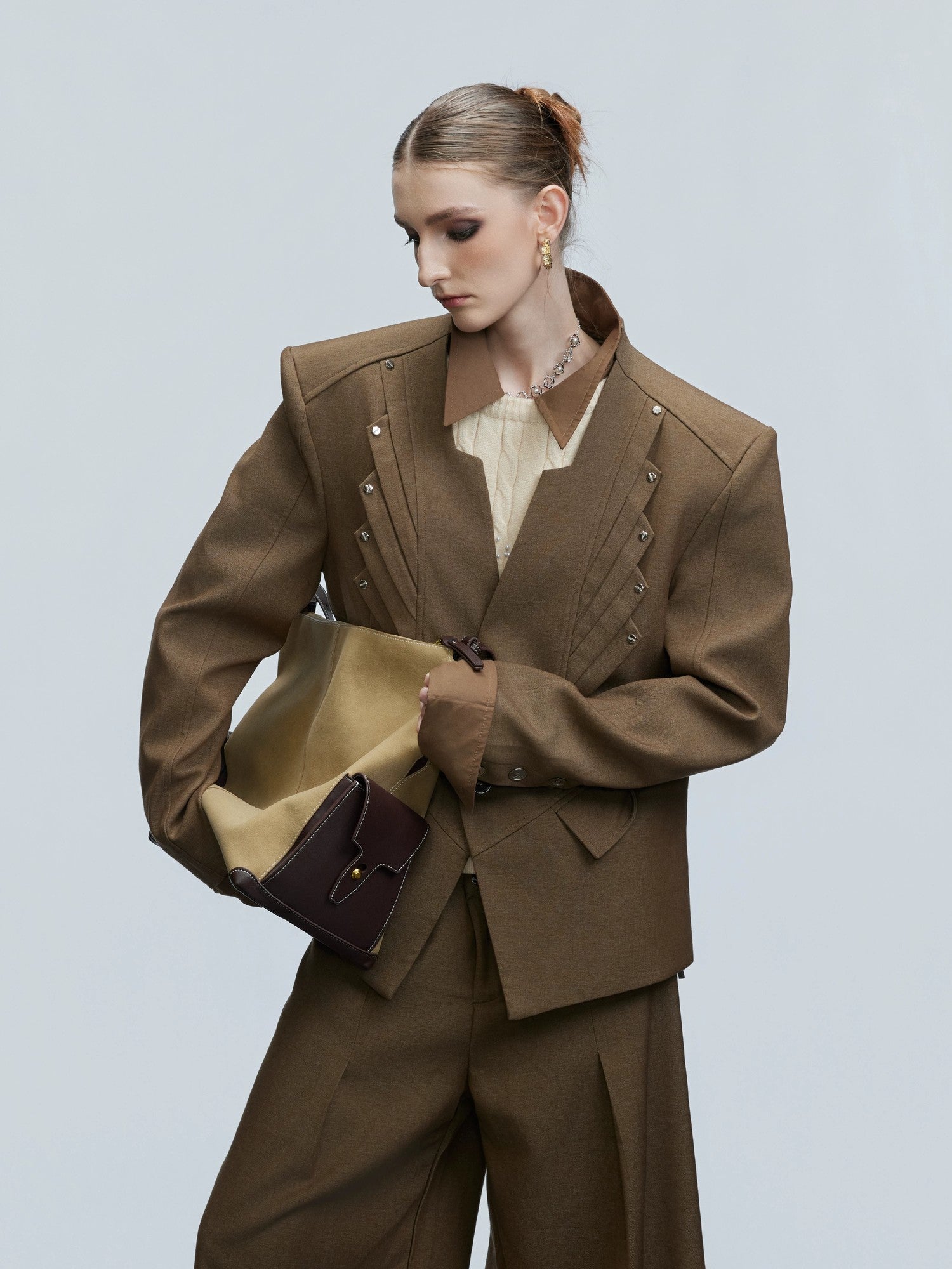 Close-up of silver rivet details on a stand collar blazer