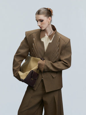 Close-up of silver rivet details on a stand collar blazer