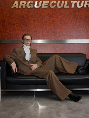 Male model wearing a red deconstructed suit in an urban setting