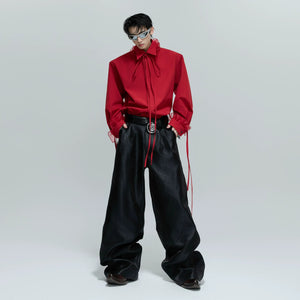 Model wearing red loose fit ribbon shirt in an urban street setting