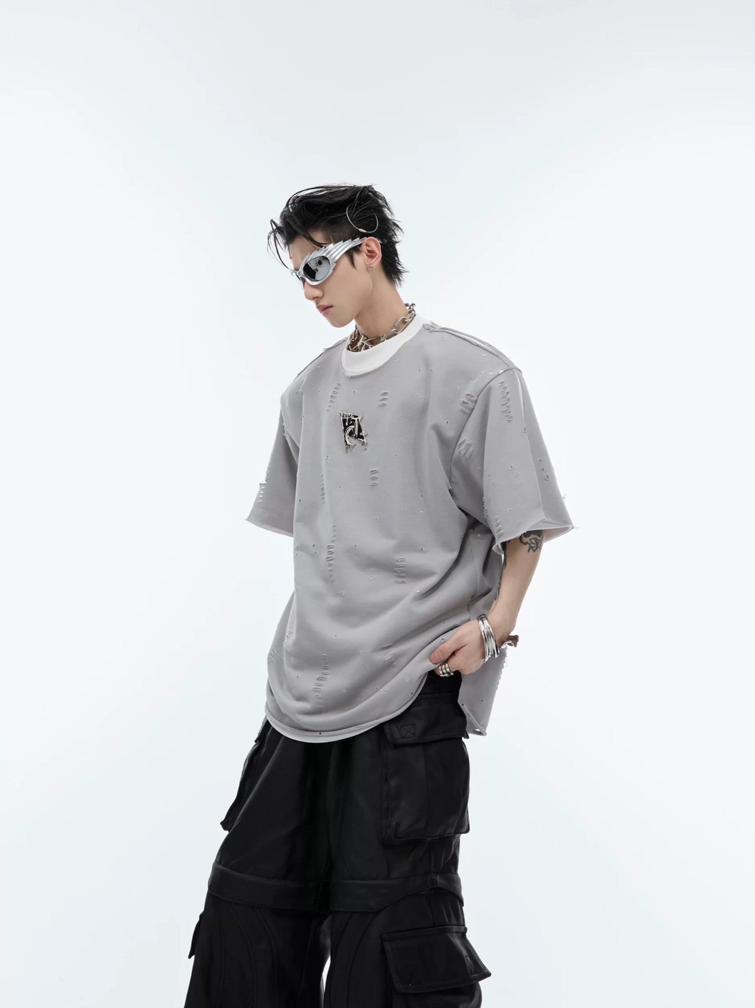 Back view of loose fit deconstructed tee showing metal details and distressing