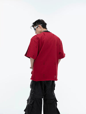 Model wearing gray deconstructed shoulder pad tee in an urban setting