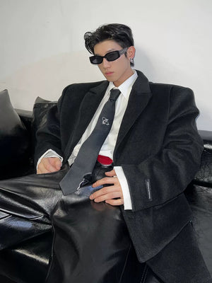 Model wearing a black distressed tie with an oversized streetwear blazer