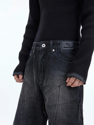Detailed shot of the metallic zipper design on structural denim pants