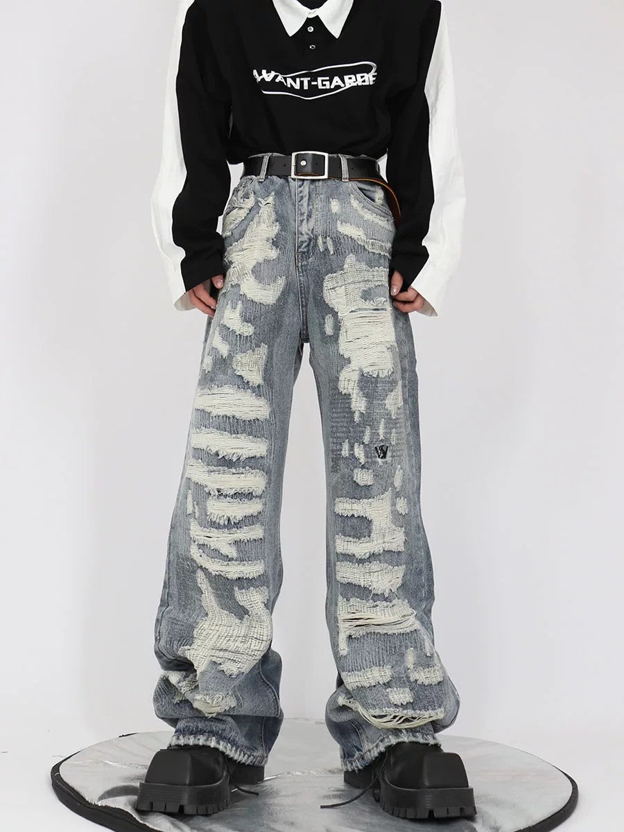 Front view of light blue vintage distressed baggy jeans with heavy destruction design