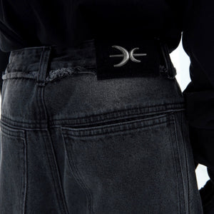 Detailed shot of knee cutout and patchwork design on denim