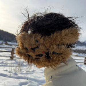 Side profile of designer faux fur earmuffs with leather accents