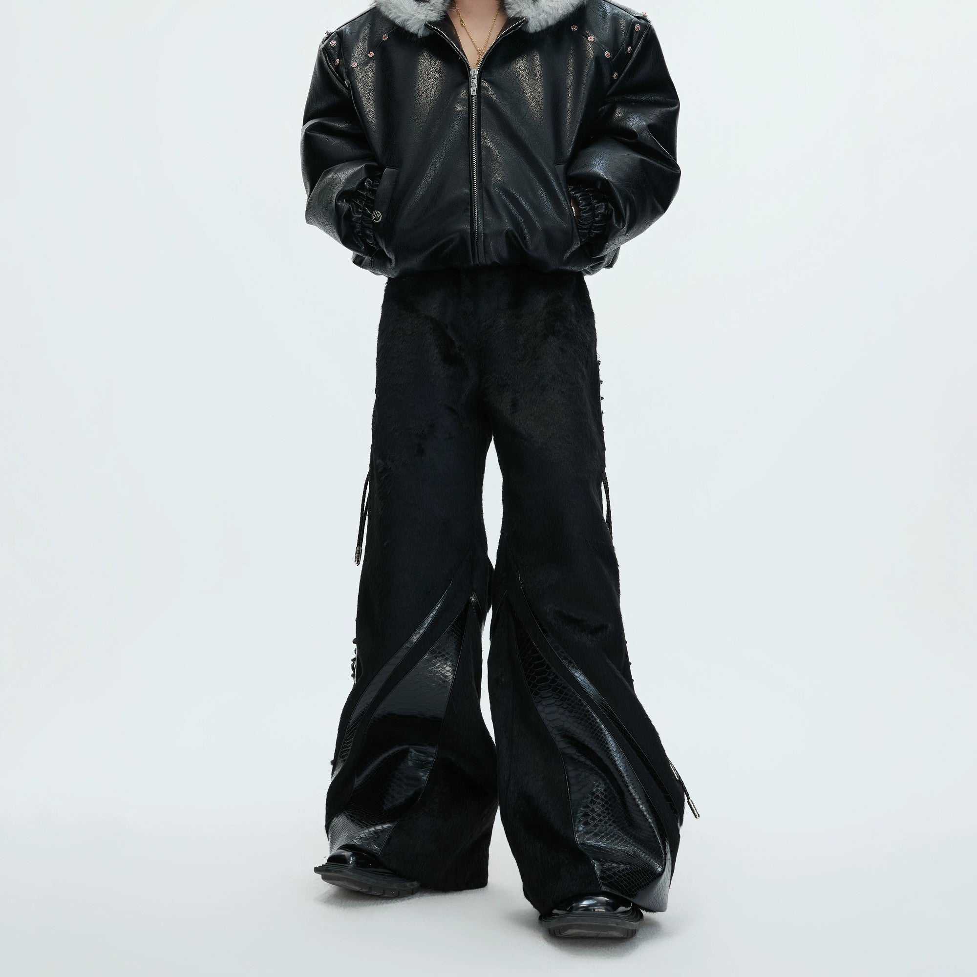 Close-up of the croc-embossed leather and faux pony hair texture on the trousers.