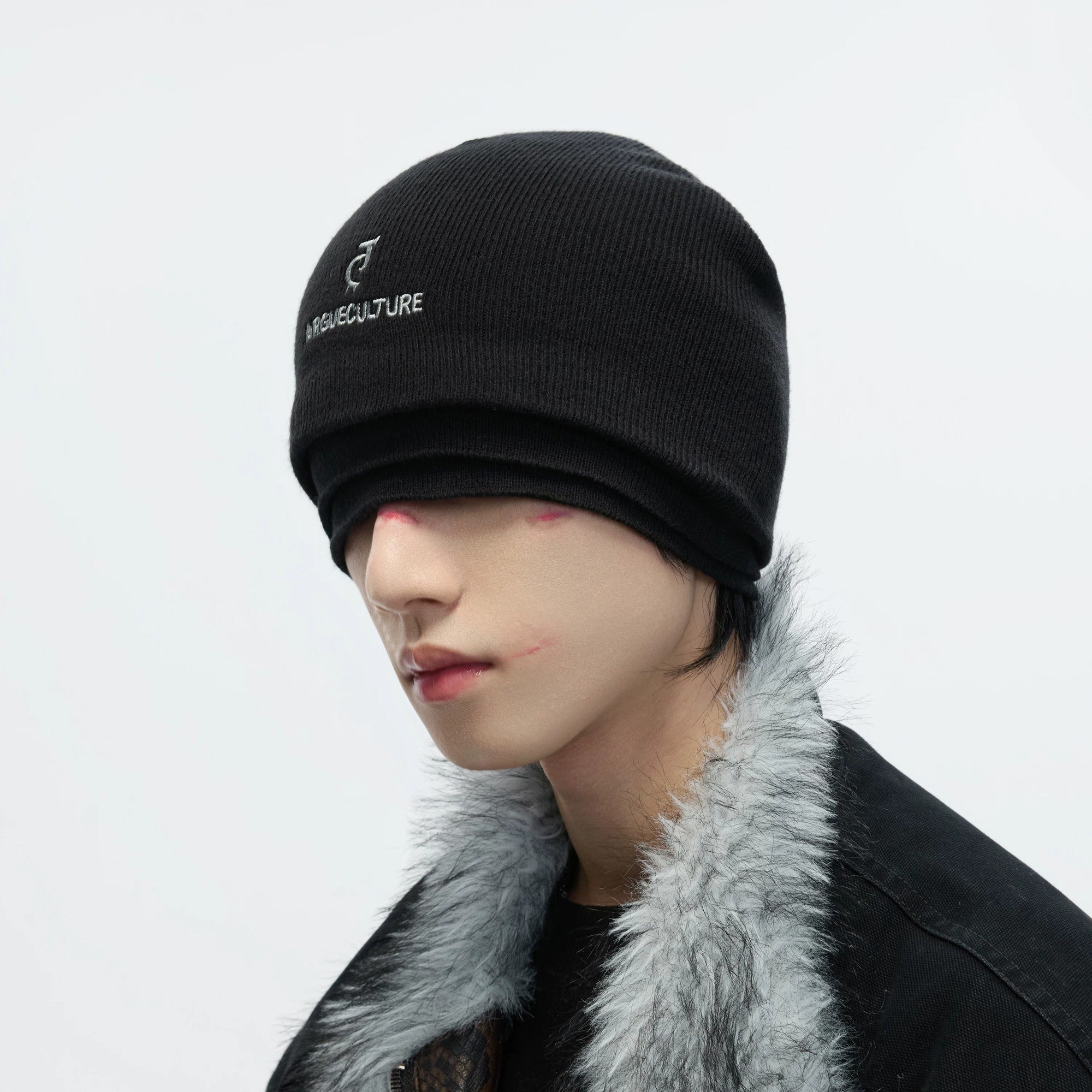 Close up of distressed knit texture and white embroidery on black hat