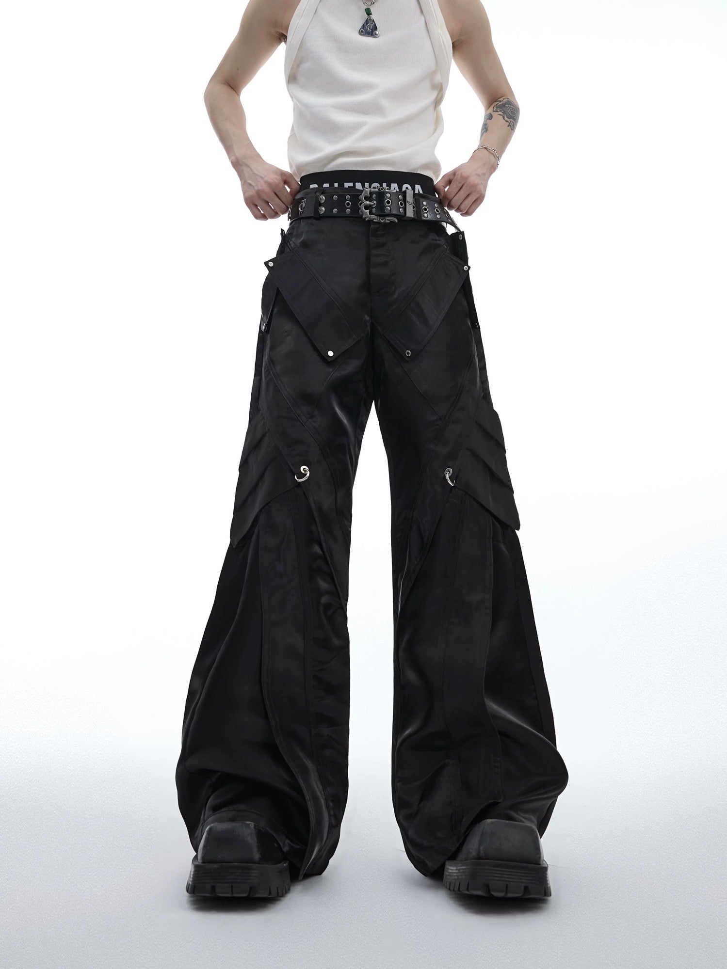 Front view of black liquid shine flared leather pants with deconstructed details.