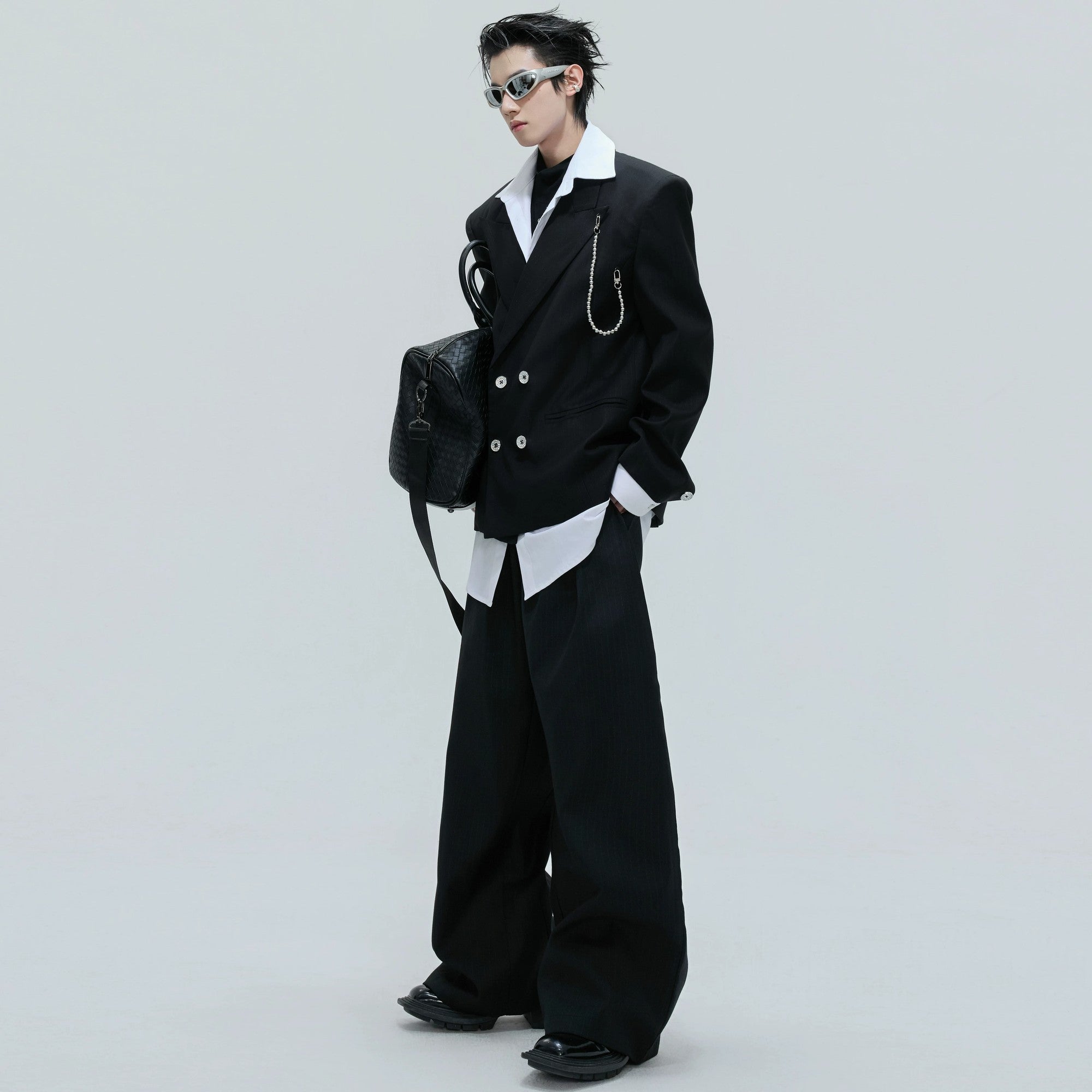 Model wearing deconstructed two-piece streetwear suit set in black