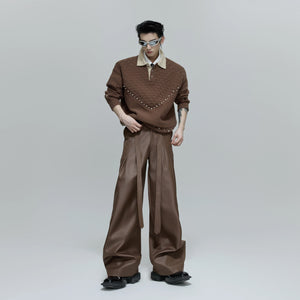 Male model styling glossy pleated trousers for a streetwear look
