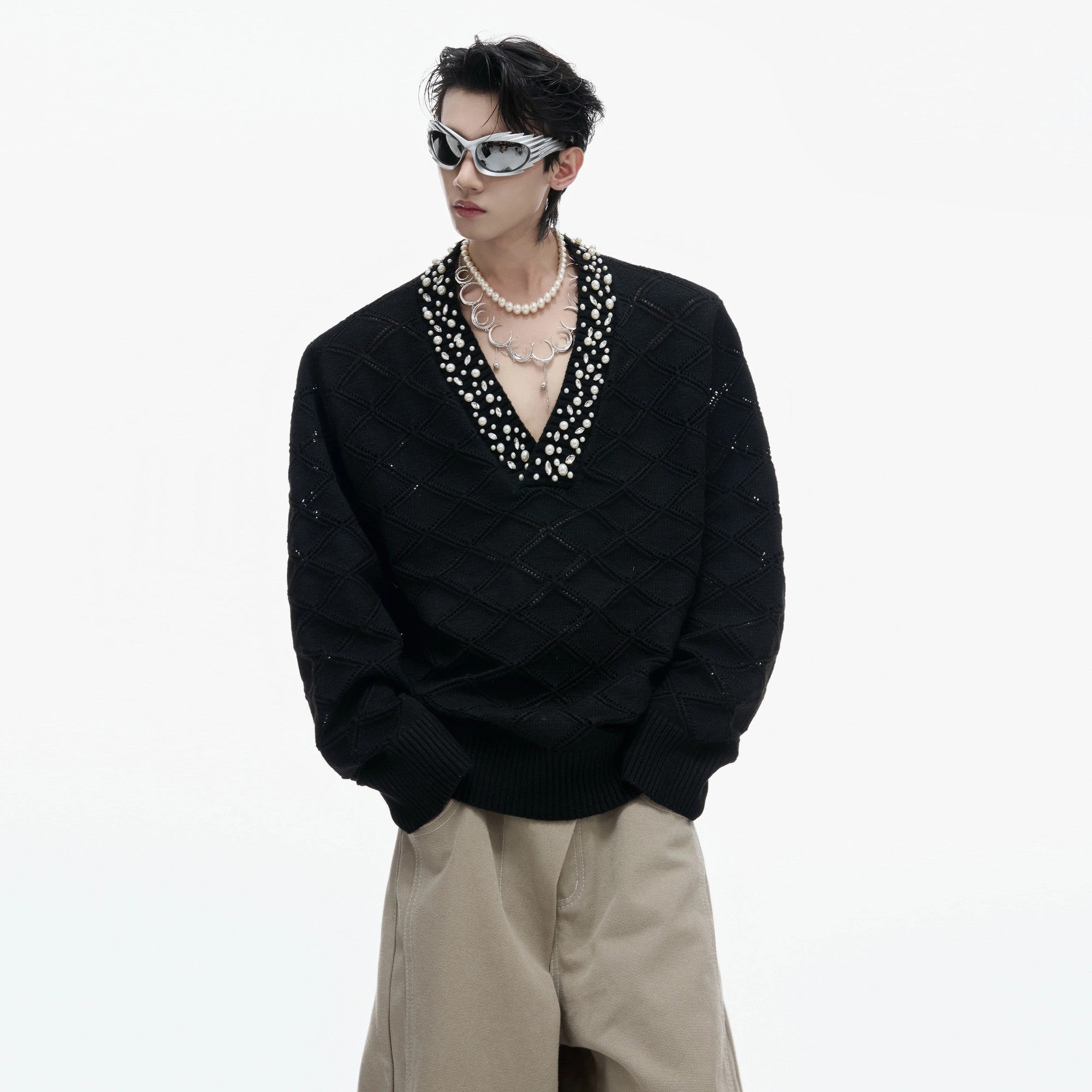 Close-up of the rhinestone and pearl embellishments on argyle knit fabric