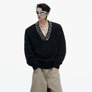 Close-up of the rhinestone and pearl embellishments on argyle knit fabric