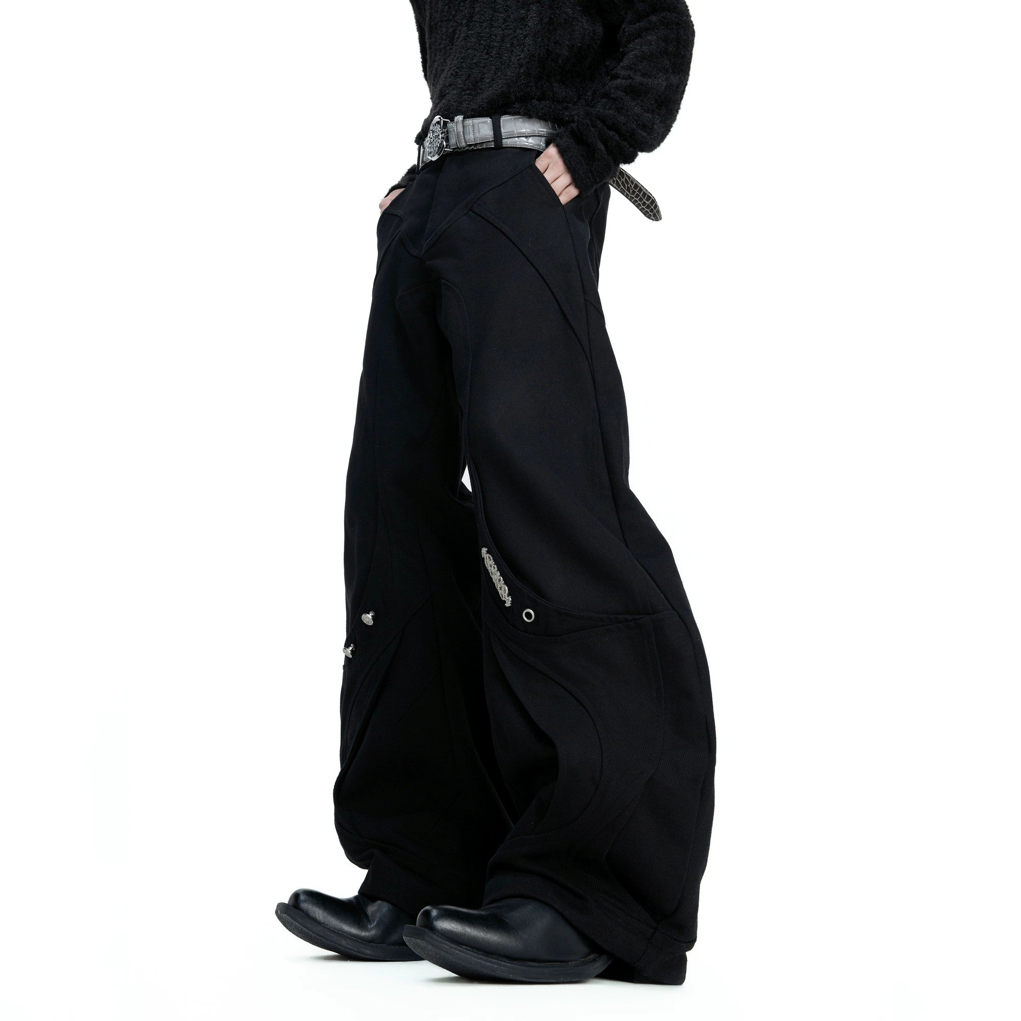 Side profile of deconstructed curved canvas pants showing unique silhouette