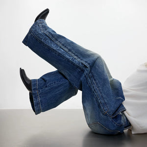 Male model wearing embroidered wide-leg jeans in a street setting