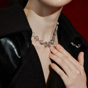 Model wearing a layered metal choker in a streetwear setting.