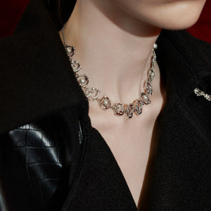 A flat lay of the layered moissanite style necklace on a dark background.