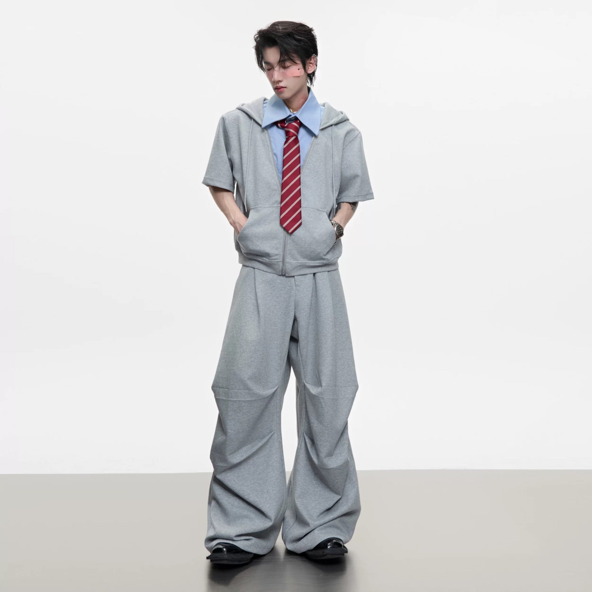 Front view of grey deconstructed short sleeve hoodie and shorts set