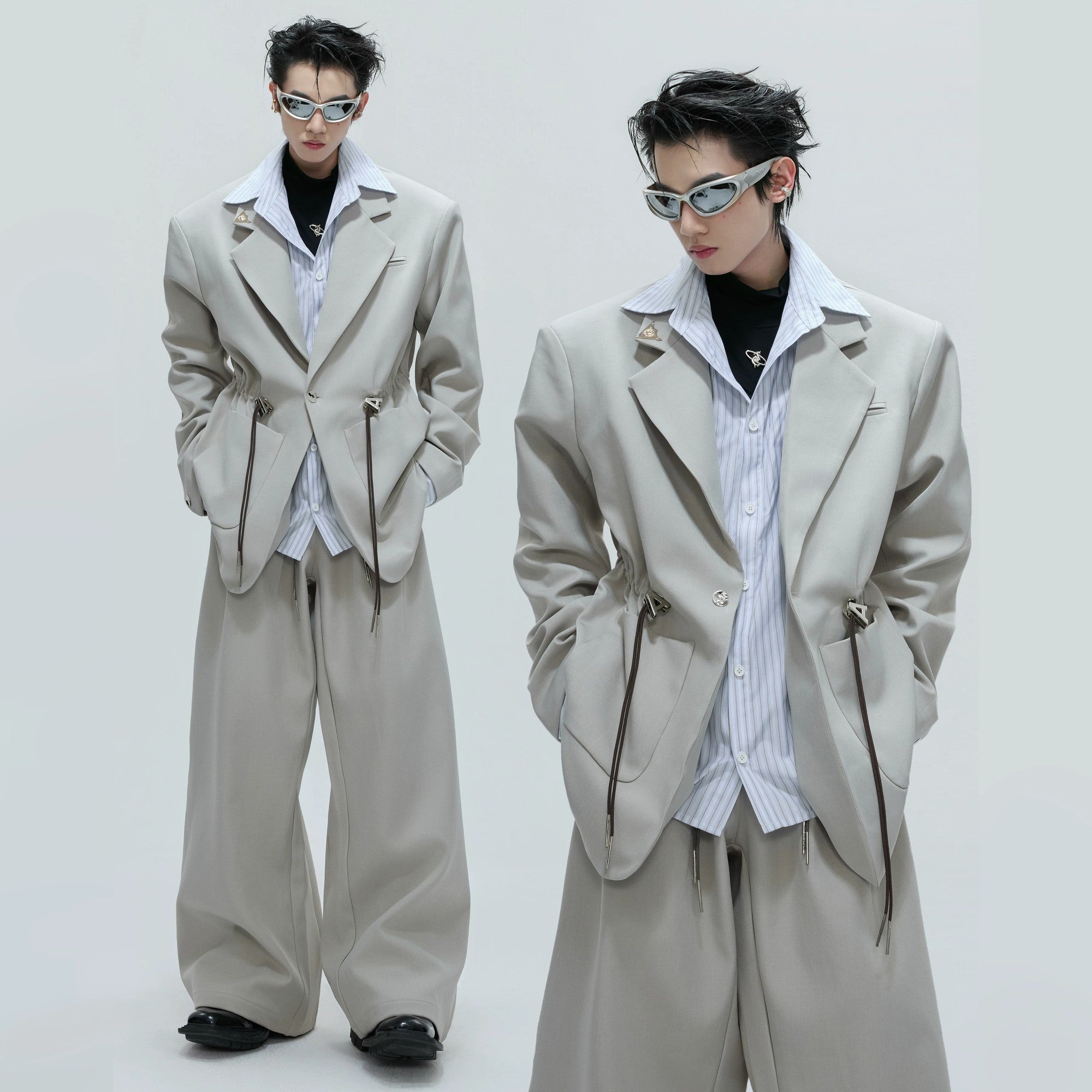 Front view of a male model wearing a black 2-in-1 layered striped blazer with cinch waist.