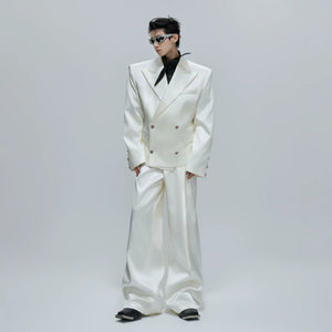 Man wearing a black liquid gloss oversized suit jacket and flared pants