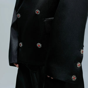 Side view of black micro-flared trousers with a liquid metallic finish